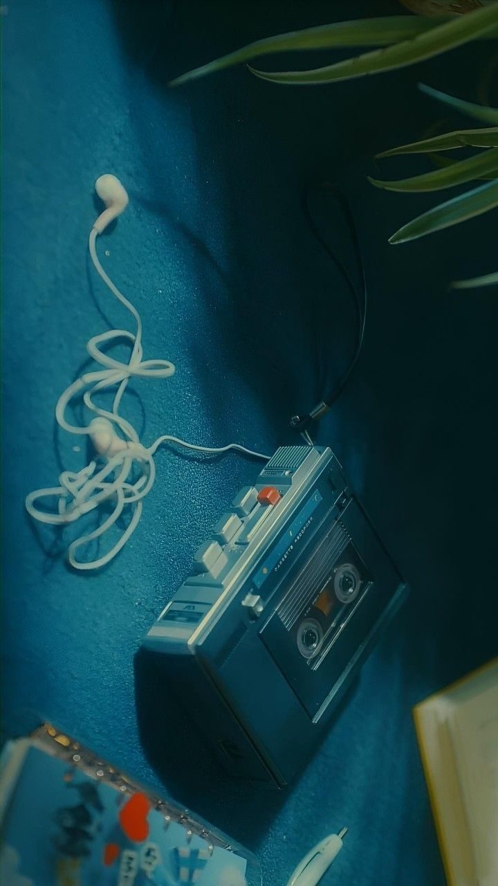 A cassette player and earphones on a blue cloth