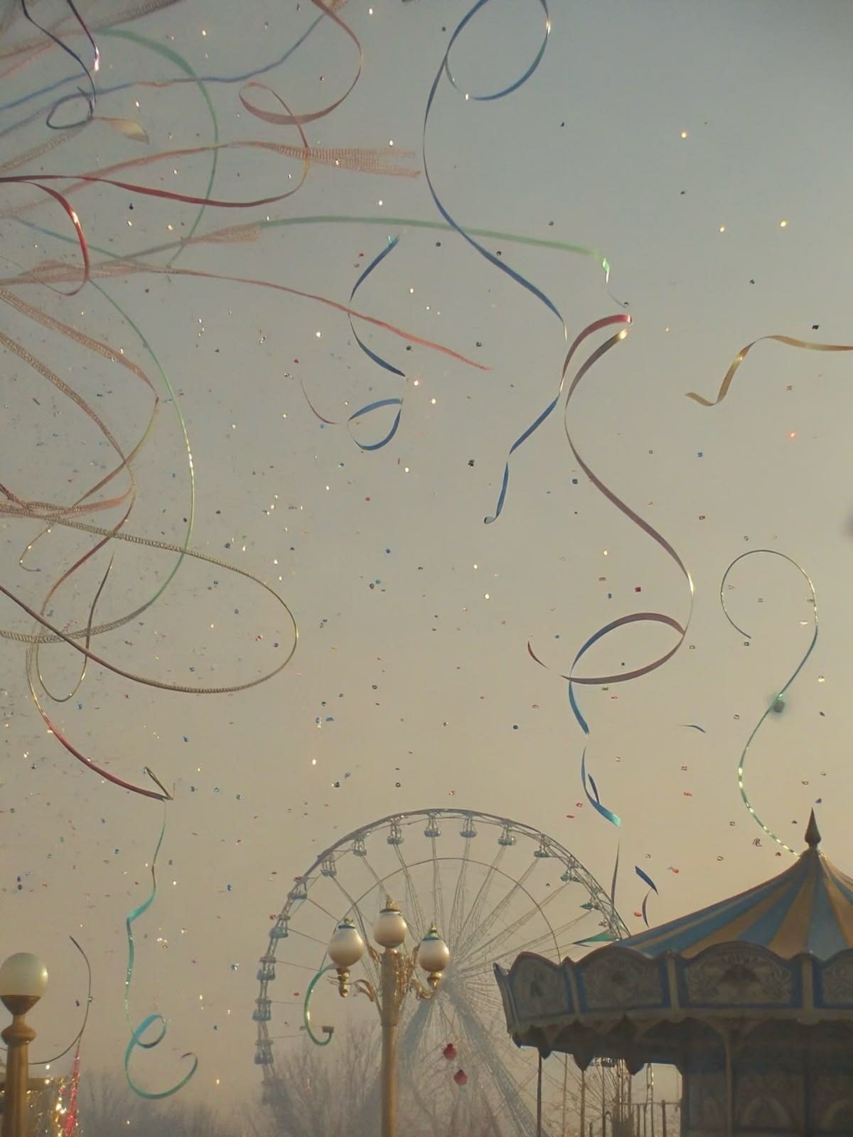 Ribbons and confetti over a fairground at dusk